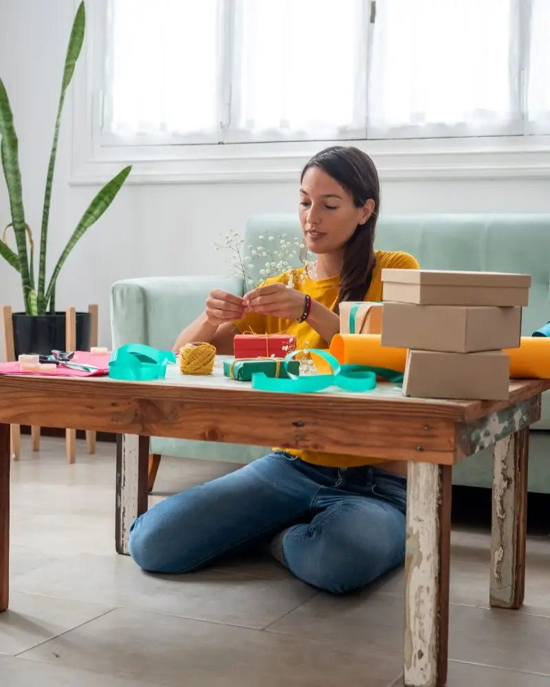 Woman wrapping handmade gifts at home.
