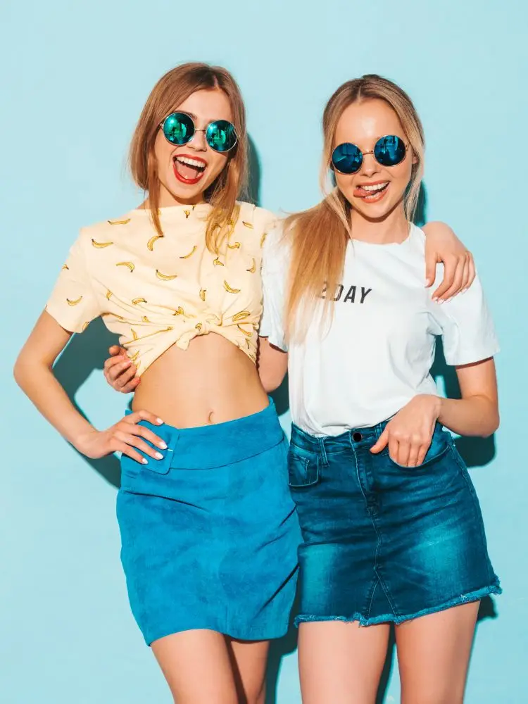 Elegant women showcasing their outfits in a photoshoot.